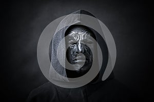 Scary figure in hooded cloak with mask photo