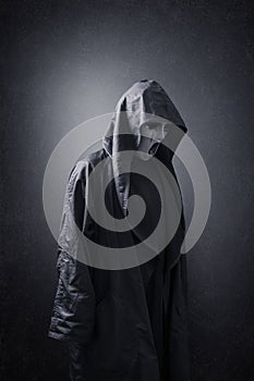 Scary figure with mask in hooded cloak