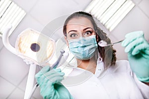 scary and funny dentist working with a patient in protective work wear