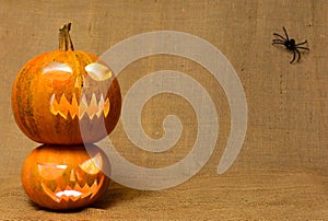 Scary glowing pumpkins faces. Scary Halloween pumpkins on a burlap background.