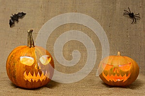 Scary glowing pumpkins faces. Scary Halloween pumpkins isolated on a burlap background.