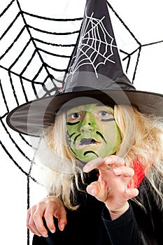 Scary green witch for Halloween with spiderweb