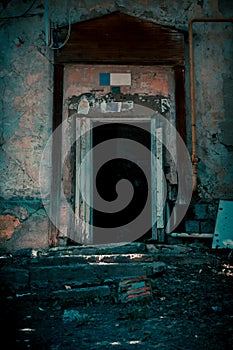 Scary grunge background in horror style, an open door entrance to a dangerous staircase of an old house, steps and