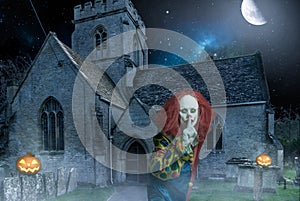 Scary halloween clown in front of an old church at night