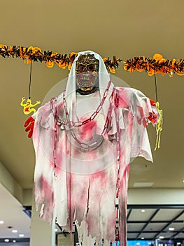 Scary Halloween holiday decoration with bloody ghost hang on ceiling