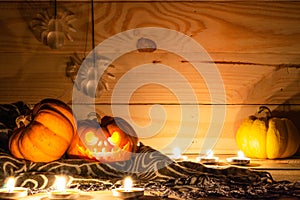 Scary Halloween pumpkins and spider on a wooden background with space for text. Halloween card concept. Spooky glowing faces with