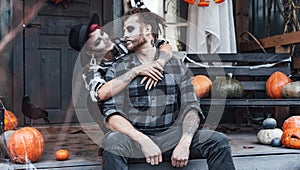 Scary love family couple man,woman celebrating halloween.Terrifying black skull half-face makeup,witch costumes.Stylish