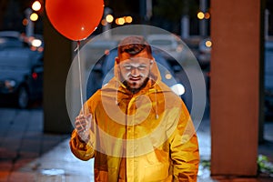 Scary man with balloon walking in night park