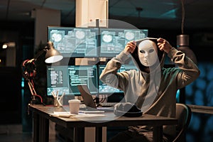 Scary masked hacker installing virus to hack system