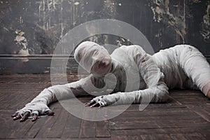 Scary mummy creeps on you. The girl with the bandage Crawling on the floor. photo