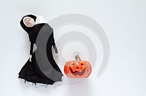Scary nun ghost that the head at shoulder and no mouth with pumpkin.