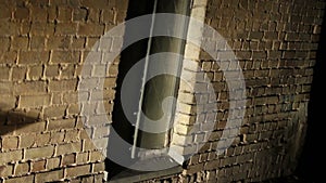 Scary place, grated window in old brick wall, abandoned building, criminal lair