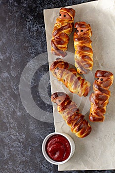 Scary sausage mummies in dough for kids party. Funny crazy Halloween food for children