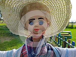 scary scarecrow with blue eyes in the daytime in summer photo