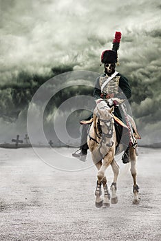 Scary skeleton Napoleon officer riding a white horse with grave crosses behind him in background and with dark and