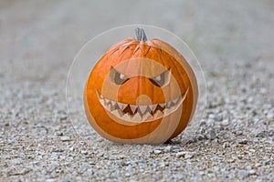 Scary smiling halloween pumpkin with nasty face on ground