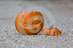 Scary smiling halloween pumpkin with nasty face on ground