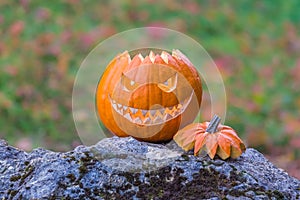 Scary smiling halloween pumpkin with nasty face on a stone