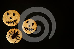 Scary and terribly tasty cookies with emoticons on a black background.