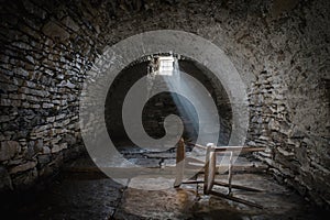Scary underground, old dark cellar with an old abandoned chair
