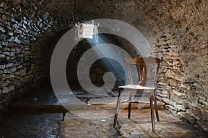 Scary underground, old dark cellar with an old abandoned chair