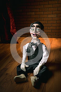 Scary ventriloquist doll sitting on the floor