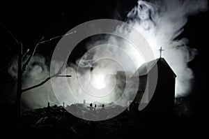 Scary view of zombies at cemetery dead tree, moon, church and spooky cloudy sky with fog, Horror Halloween concept