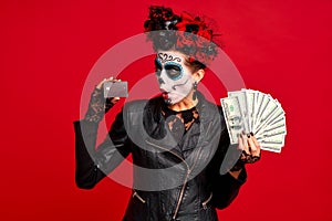 Scary young creepy lady calavera. wears artistic make-up for the feast of all the dead.Wears black leather jacket and lace gloves