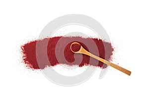 Scattered Beetroot powder pile and wooden spoon on white background. Food additive E162, natural pigment beet red. Dry beet powder