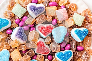 Scattered candy and sugar sweets in the shape of heart, cute tasty jelly beans