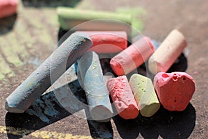 Scattered colorful crayon chalks on black boar