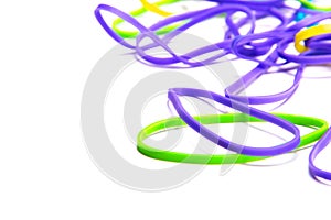 Scattered colorful green purple and blue rubber bands on a white table with room for text.