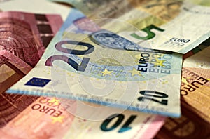 Scattered euro banknotes in denominations of five euros, ten euros, twenty euros, fifty euros, mixed banknotes as background