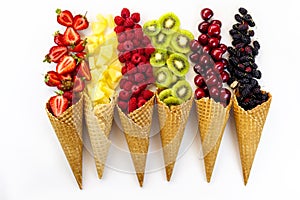 Scattered fruits in waffle, cone cups on a whait background