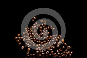 Scattered grains of roasted, fragrant coffee on a black background, isolation, flat-lay, copy space