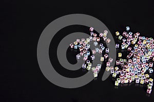 Scattered jewelry beads on a black background with text space