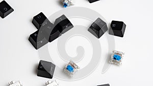Scattered Keycaps and Keyswitches for Mechanical Keyboards On White Background