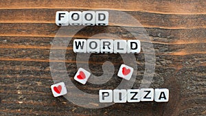 Scattered Letter Dice Spell Out Food Loves World Pizza on Wooden Surface