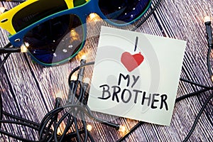 Scattered Lighted Tiny LED Stringlight on Wooden Surface. Two Colorful Sunglasses with Light Reflecting. Handwritten