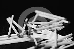 Scattered matches on dark background. Black and white