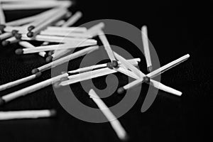 Scattered matches on dark background. Black and white