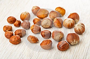 Scattered peeled hazelnuts and hazelnuts in shell on table