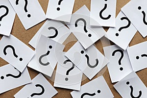 Scattered question marks printed on white paper