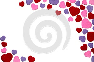 Scattered red, purple and pink felt hearts isolated on a white background, corner, border - valentines, love
