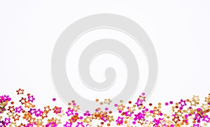 Scattered round confetti and in the form of flowers pink, gold and orange color on a white background. Copy space. Spring and