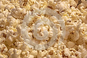 Scattered salted popcorn, food texture background.