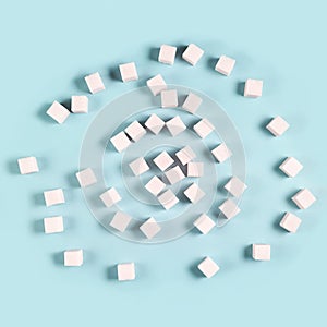 Scattered sugar cubes on light blue background in random pattern
