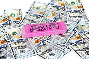 Scattered US dollars with a pink eraser on top with really big mistakes message.