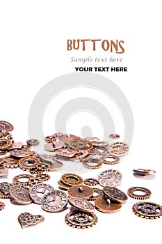 Scattered vintage copper metal buttons on a white background, shaped as gears, hearts, and clock pieces. Steam Punk