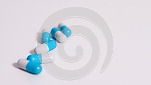 Scattered white pills on blue table. Mock up for special offers as advertising, web background or other ideas. Medical